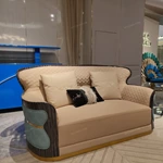 Cream Curved Sofa with Diamond-Quilted Backrest, Dark High-Gloss Sides and Teal Accent Panels